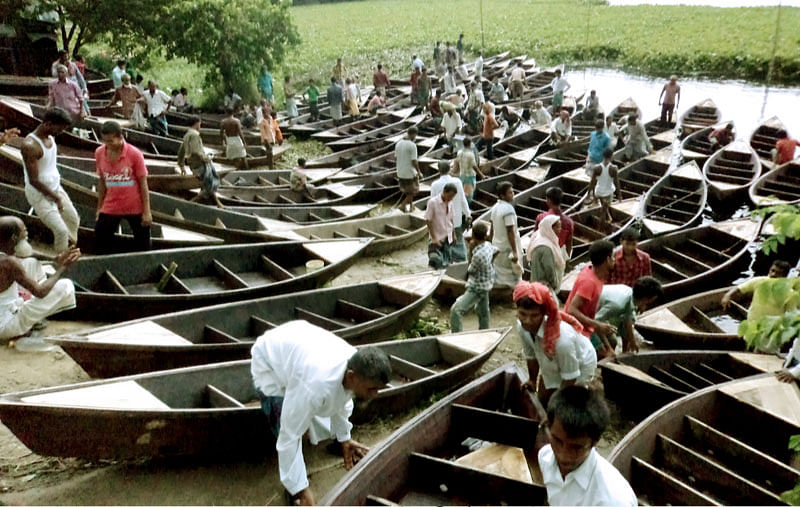 বিক্রির জন্য রাখা নৌকা। ক্রেতারা নৌকা কেনার জন্য দেখছেন। ছবি: লেখক