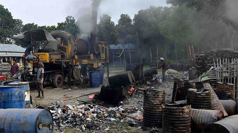 রাস্তার কাজের জন্য বিটুমিন পোড়ানোর ফলে বিষাক্ত ধোঁয়ায় অতিষ্ঠ এলাকাবাসী। দীর্ঘলকান্দি মাদ্রাসা মাঠ, বড়াইগ্রাম, নাটোর, ১১ জুন। ছবি: প্রথম আলো