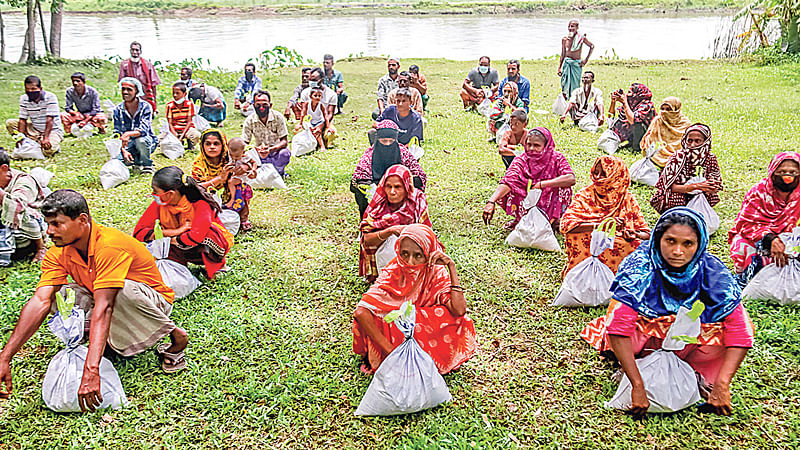 প্রথম আলো ট্রাস্টের উদ্যোগে ঘূর্ণিঝড় আম্পানে ক্ষতিগ্রস্ত ৬০টি পরিবারের মধ্যে খাদ্যসহায়তা দেওয়া হয়। বুধবার বরিশাল নগরের কালিজিরা নদীর তীরে অবস্থিত দক্ষিণ জাগুয়া এলাকায়।  ছবি: প্রথম আলো