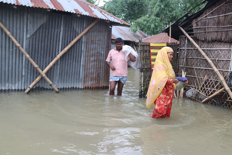 রংপুরের গঙ্গাচড়া উপজেলায় বন্যার পানি হাঁটুসমান হয়েছে। পানি ঢুকে পড়েছে ঘরবাড়িতে। এ অবস্থায় ঘর থেকে মালামাল সরিয়ে নেওয়া হচ্ছে। পূর্ব শংকরদহ, গঙ্গাচড়া, রংপুর, ২৮ জুন। ছবি: মঈনুল ইসলাম