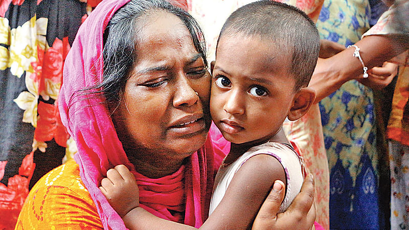 পাপ্পু মিয়ার স্ত্রী ইয়াসমিন বেগমের আহাজারি, কোলে সন্তান সাদিয়া। মঙ্গলবার দুপুরে মিরকাদিমের নৈদিঘীর পাথর এলাকার বাড়িতে।  দিনার মাহমুদ