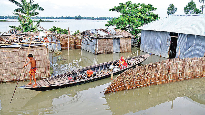 সপ্তাহখানেক ধরে পানিতে তলিয়ে আছে কুড়িগ্রামের বিভিন্ন চরাঞ্চল। ঘরে পানি ঢুকে পড়ায় কয়েক দিন ধরে অন্যের বাড়িতে আশ্রয় নিয়েছে পরিবারটি। তবে মাঝেমধ্যে নৌকা নিয়ে নিজের বাড়িটি দেখতে আসে। গতকাল কুড়িগ্রাম সদরের ভগবতীপুর গ্রামে।  ছবি: মঈনুল ইসলাম