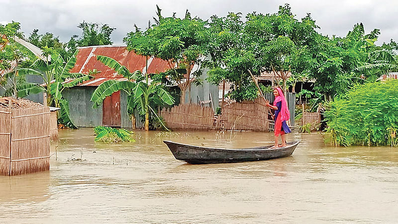 মাদারীপুরে বন্যায় পানিবন্দী চরাঞ্চলের দুই হাজারের বেশি পরিবার। চলাচলের একমাত্র বাহন নৌকা। গতকাল দুপুরে শিবচর উপজেলার চরজানাজাত এলাকায়।  ছবি: প্রথম আলো