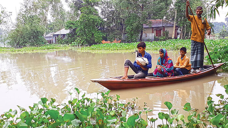 তিস্তা নদীর পানি বৃদ্ধি পেয়েছে। নিরাপদ আশ্রয়ে ছুটছে বন্যাকবলিত মানুষ। গতকাল দুপুরে নীলফামারীর ডিমলা উপজেলার ছোটখাতা গ্রামে।  ছবি প্রথম আলো