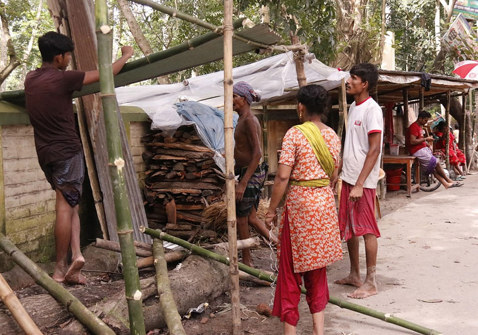 সড়কে টিন ও বাঁশ দিয়ে মাথা গোঁজার ব্যবস্থা করা হচ্ছে। ১৭ জুলাই। ছবি: প্রথম আলো