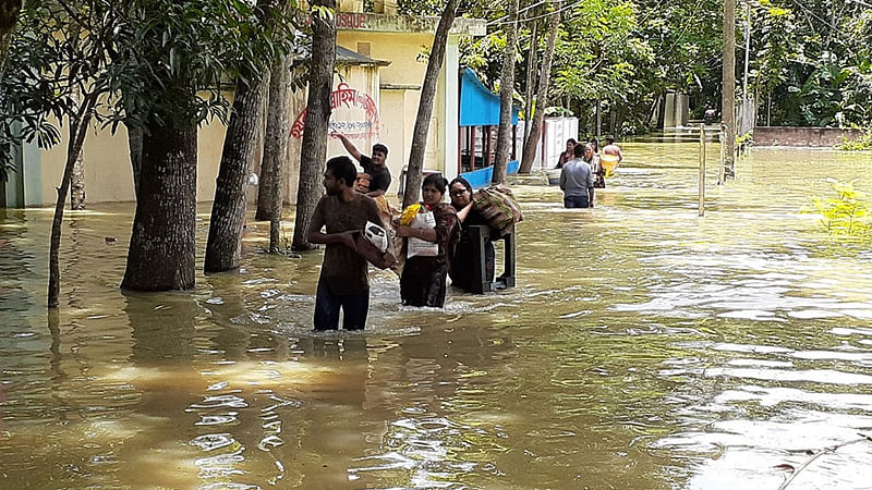 বন্যার পানিতে তলিয়ে গেছে ভাজনডাঙ্গার বিভিন্ন সড়ক। নিরাপদ আশ্রয়ের খোঁজে ছুটছে মানুষ। ১৭ জুলাই। ছবি: প্রথম আলো