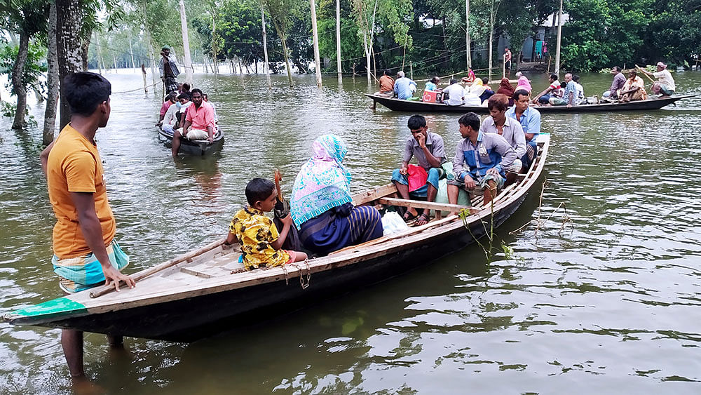 রাস্তাঘাট ও ঘরবাড়ি জলমগ্ন। লোকজনের চলাচলের একমাত্র ভরসা নৌকা। জামালপুরের সরিষাবাড়ী উপজেলার ধানাটা গ্রামে। ছবি: আবদুল আজিজ।