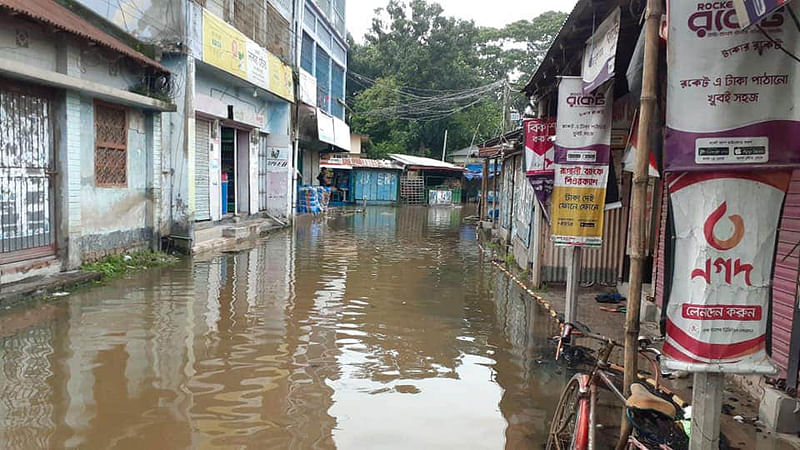 শুক্রবার সকাল থেকে সিংড়া সদরে আত্রাই নদের পানি ঢুকতে শুরু করে। দুপুর নাগাদ সদরের সব রাস্তা পানিতে ডুবে যায়। থানার মোড় এলাকায়। ছবি: প্রথম আলো