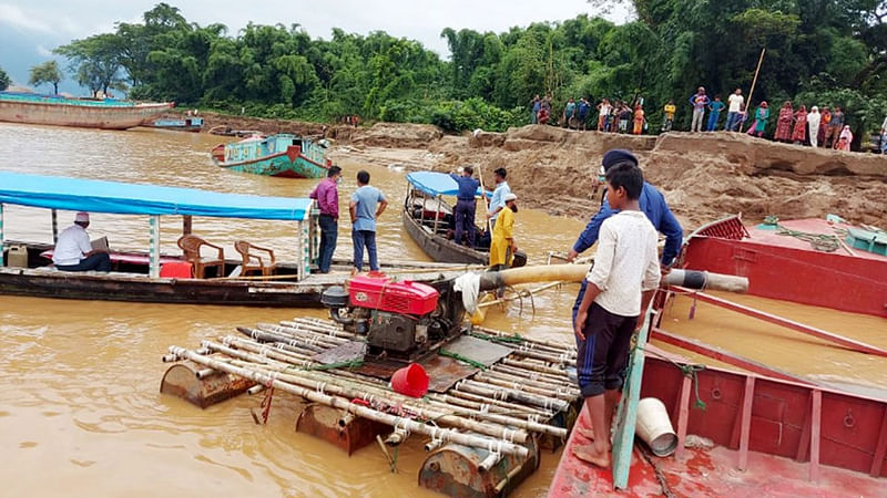 নৌকার সঙ্গে বাঁশের ভেলার মধ্যে স্থাপন করা খননযন্ত্র দিয়ে তোলা হচ্ছিল বালু ও ছোট পাথর। টাস্কফোর্সের অভিযানে এসব যন্ত্র ধ্বংস করা হয়। ২৭ জুলাই। ছবি: প্রথম আলো