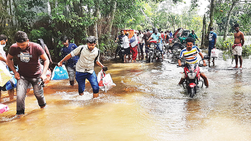 বন্যায় মানিকগঞ্জ-ঝিটকা পাকা সড়কের তিন স্থান ধসে গেছে। এ কারণে প্রায় দুই সপ্তাহ ধরে জেলা সদর থেকে হরিরামপুর উপজেলায় বাস চলাচল বন্ধ রয়েছে। ভোগান্তিতে পড়েছেন যাত্রীরা। গতকাল দুপুরে ঘিওরের উভাজানী এলাকায়।  ছবি: আব্দুল মোমিন