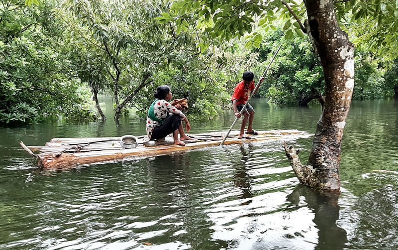 মানিকগঞ্জে নিচু এবং চরাঞ্চলের বিস্তীর্ণ এলাকা এখনো পানির নিচে। পথঘাট পানির নিচে থাকায় নৌকা কিংবা কলাগাছের ভেলাই এখন যাতায়াতে ভরসা। শনিবার মানিকগঞ্জ সদর উপজেলার নতুন বসতি গ্রামে। ছবি: প্রথম আলো