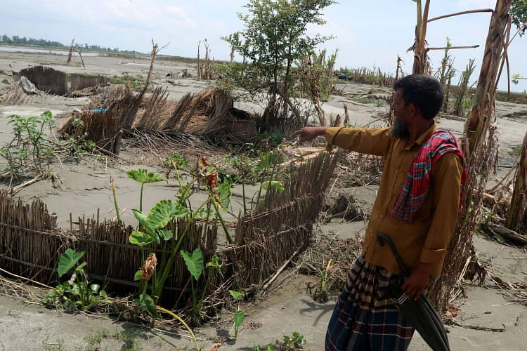 বন্যায় চরটি বিলীনের পথে। এখানে আশরাফ আলীর বসতঘর ছিল। বন্যার পানিতে ভেসে যাওয়া বসতঘরটি দেখাচ্ছেন তিনি। আজ মঙ্গলবার দুপুরে বগুড়ার সারিয়াকান্দি উপজেলার হাটবাড়িচর থেকে ছবিটি তোলা। ছবি: সোয়েল রানা