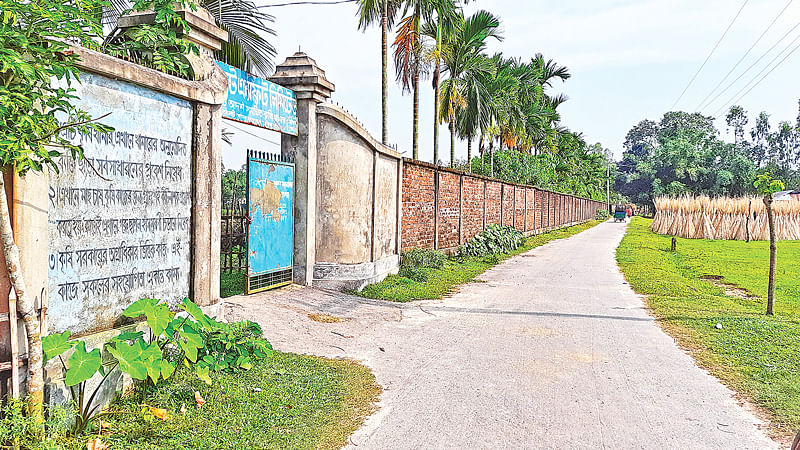 নদীর মধ্যে নির্মাণ করা হয়েছে সেতুবিহীন আড়াআড়ি সড়ক। বাঁয়ে ৩০ একর নদীর জায়গা দখল করে তৈরি করা হয়েছে মাছের খামার, যাতে বন্ধ হয়ে গেছে পানিপ্রবাহ। গত রোববার কুড়িগ্রামের রাজারহাটের পাঠানহাট-কৈলাসকুটি সড়কে।  ছবি: প্রথম আলো