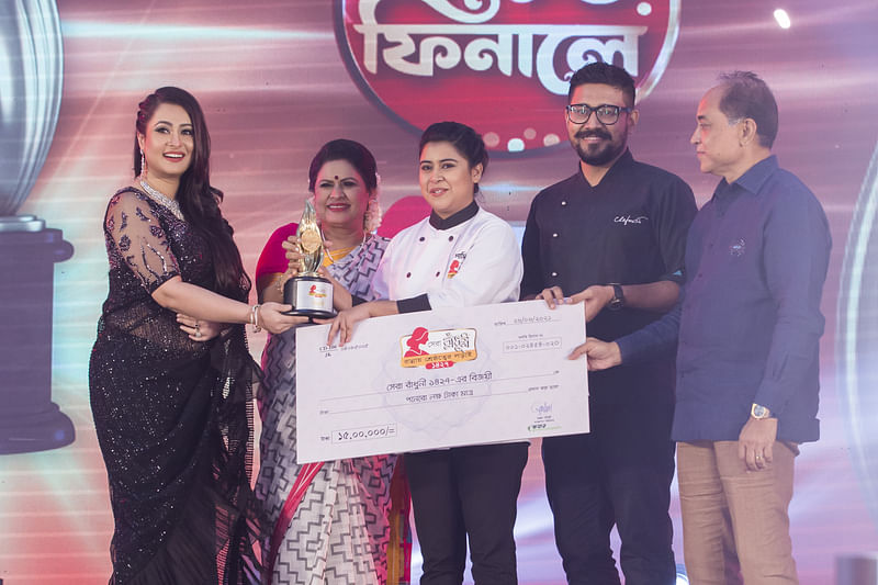 ‘সেরা রাঁধুনী ১৪২৭’–এর বিজয়ীর হাতে স্মারক ও পুরস্কার তুলে দিচ্ছেন (বাঁ থেকে) বিচারক দিলারা হানিফ পূর্ণিমা, রহিমা সুলতানা, বিজয়ী সাদিয়া তাহের, বিচারক শুভব্রত মৈত্র ও স্কয়ার ফুড অ্যান্ড বেভারেজ লিমিটেডের ব্যবস্থাপনা পরিচালক অঞ্জন চৌধুরী। ছবি: সংগৃহীত