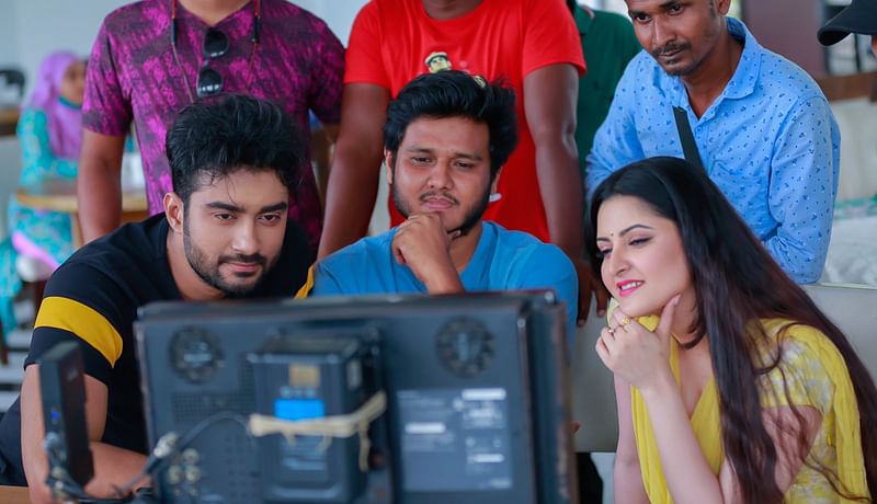 ‘মুখোশ’ চলচ্চিত্রের শুটিং সময়ে মনিটরের দিকে তাকিয়ে আছেন পরীমনি (বামে), পরিচালক ইফতেখার শুভ (মাঝে) ও চিত্রনায়ক রোশান (ডানে)