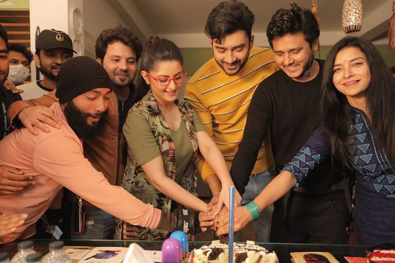 ‘মুখোশ’ চলচ্চিত্রের শুটিং সময়ে পরীমনি ও চিত্রনায়ক রোশান এবং পরিচালক ইফতেখার শুভ সবাইকে নিয়ে কেক কাটছেন