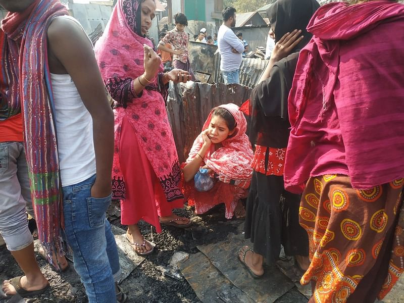 আগুনে বাড়ি পুড়ে যাওয়ায় অসহায় হয়ে বসে আছেন এক নারী