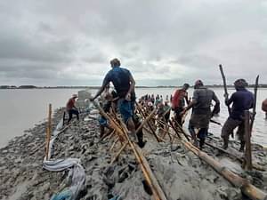 খুলনার কয়রার চরামুখা এলাকায় কপোতাক্ষ নদের ভেঙে যাওয়া বাঁধ মেরামতের চেষ্টা করেন স্থানীয় লোকজন