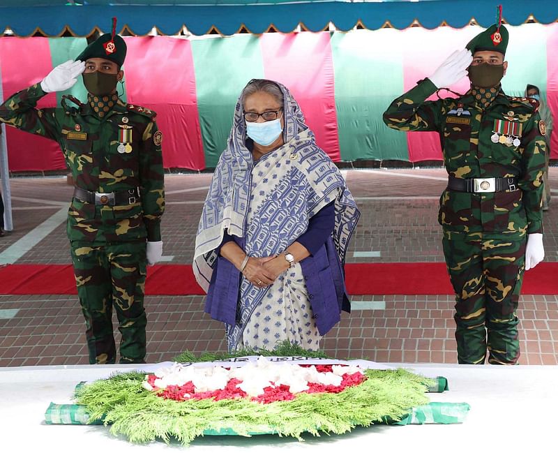 টুঙ্গিপাড়ায় বঙ্গবন্ধুর সমাধিতে পুষ্পস্তবক অর্পণের পর নীরবে দাঁড়িয়ে শ্রদ্ধা জানান প্রধানমন্ত্রী শেখ হাসিনা