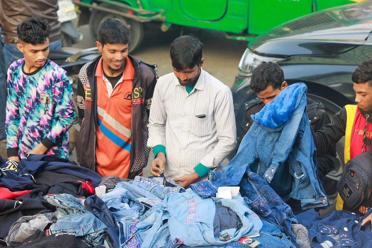 সড়কের পাশের ফুটপাত থেকে গরম কাপড় কিনছেন সাধারণ মানুষ। কারওয়ান বাজার, ঢাকা।