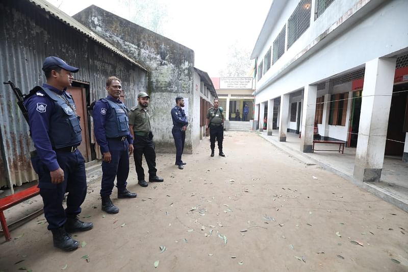 উচালিয়া পাড়া সরকারি প্রাথমিক বিদ্যালয় কেন্দ্রের বাইরে আইনশৃঙ্খলা রক্ষাকারী বাহিনীর সদস্যরা