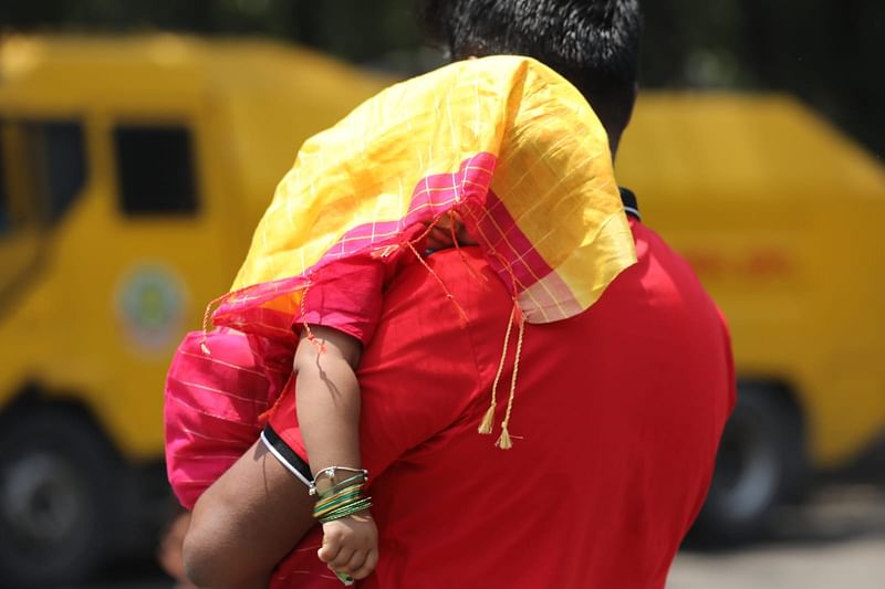 বর্ষবরণ উৎসবে এসে ঘুমিয়ে পড়েছে শিশুটি। রোদ থেকে বাঁচাতে তাকে কাপড়ে ঢেকে নিয়েছেন অভিভাবক