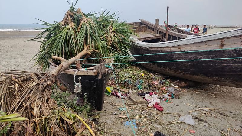  সৈকতে নৌযানের ওপর উপড়ে পড়েছে গাছ। 