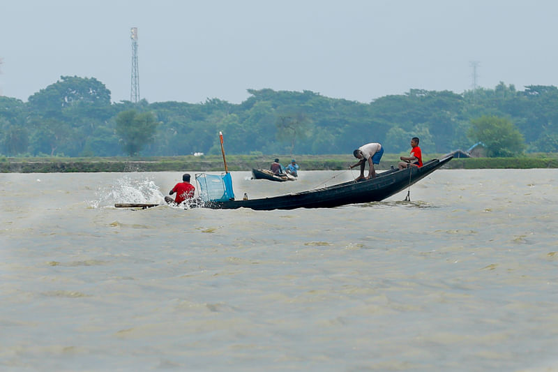 নদীতে প্রচুর ঢেউ, তা উপেক্ষা করেই জাল টানছেন জেলেরা। 