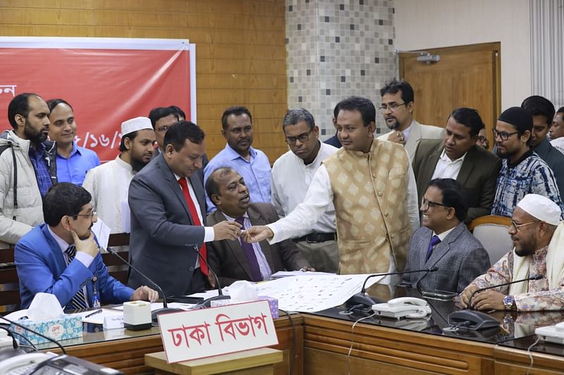 ঢাকা মহানগরের ১৫টি সংসদীয় আসনের প্রার্থীদের প্রতীক বরাদ্দ দিচ্ছেন রিটার্নিং কর্মকর্তা। রিটার্নিং কর্মকর্তার কার্যালয়, সেগুনবাগিচা, ঢাকা, ১৮ ডিসেম্বর