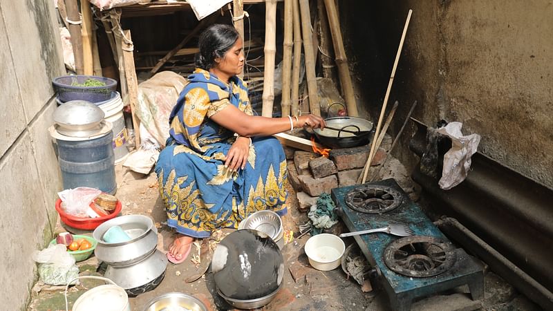 চুলায় একেবারেই গ্যাস পাচ্ছেন না সরস্বতী ঘোষ। তাই বাধ্য হয়ে ইটের চুলায় লাকড়ি জ্বালিয়ে রান্না করেন তিনি।