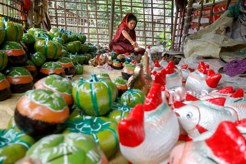 নতুন পুতুল তৈরির কাজ করছেন এক নারী। 