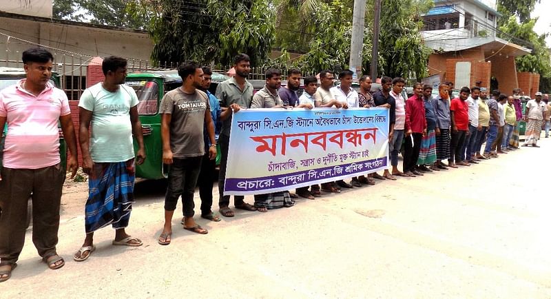 নবাবগঞ্জে চাঁদা বন্ধের দাবিতে সিএনজিচালিত অটোরিকশাচালকদের মানববন্ধন। আজ দুপুরে।ছবি: প্রথম আলো