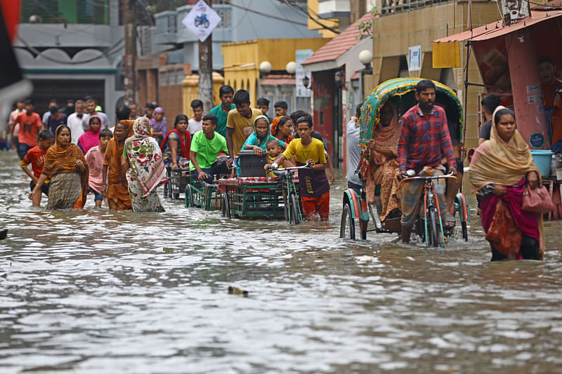 তেরো রতন এলাকায় পানি মাড়িয়ে চলাচল করছেন স্থানীয় লোকজন 