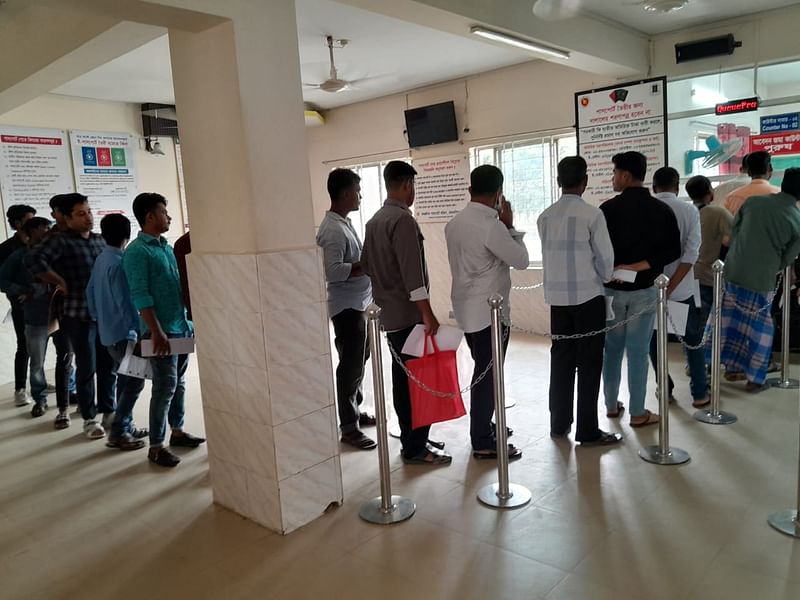 পাসপোর্টের আবেদন ফরম জমা দিতে লাইনে দাঁড়িয়েছেন লোকজন। বুধবার দুপুরে ময়মনসিংহ আঞ্চলিক পাসপোর্ট কার্যালয়েছবি: কামরান পারভেজ