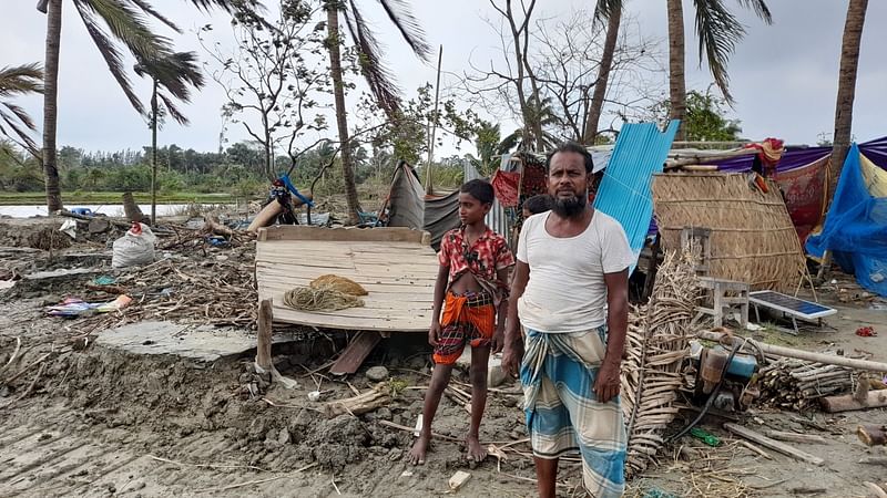 শূন্য ভিটায় নাতিকে নিয়ে আবুল খায়ের। গত রোববার নোয়াখালীর হাতিয়ার চানন্দি ইউনিয়নের পূর্ব আজিমনগর গ্রামেছবি: প্রথম আলো।