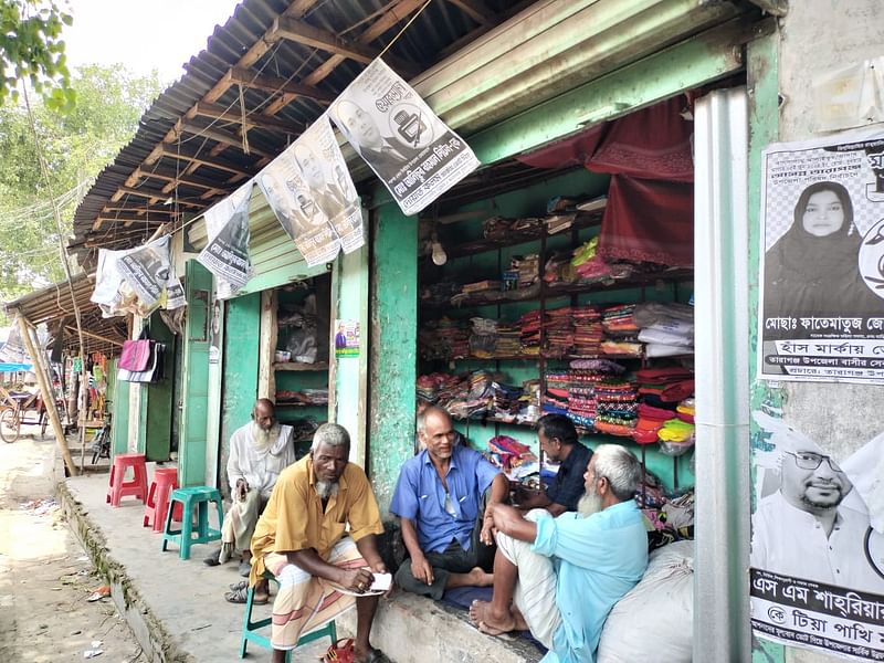 দোকানে চলছে ভোটের আলোচনা। আজ সোমবার সকালে তারাগঞ্জ উপজেলার ইকরচালী বাজারেছবি: প্রথম আলো