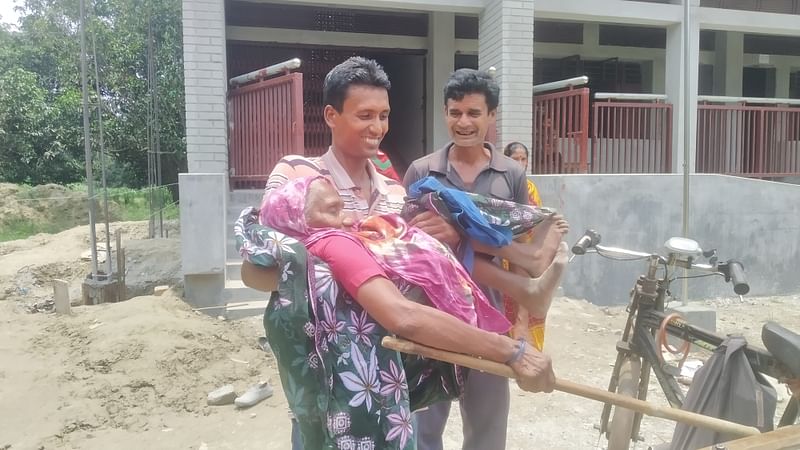 নাতির কোলে কেন্দ্রে এসে ভোট দিলেন ৯০ ছুঁই ছুঁই হালিমা বেওয়া। বুধবার দুপুরের রাজশাহীর চারঘাটের ফতেহপুর সরকারি প্রাথমিক বিদ্যালয়েছবি : প্রথম আলো