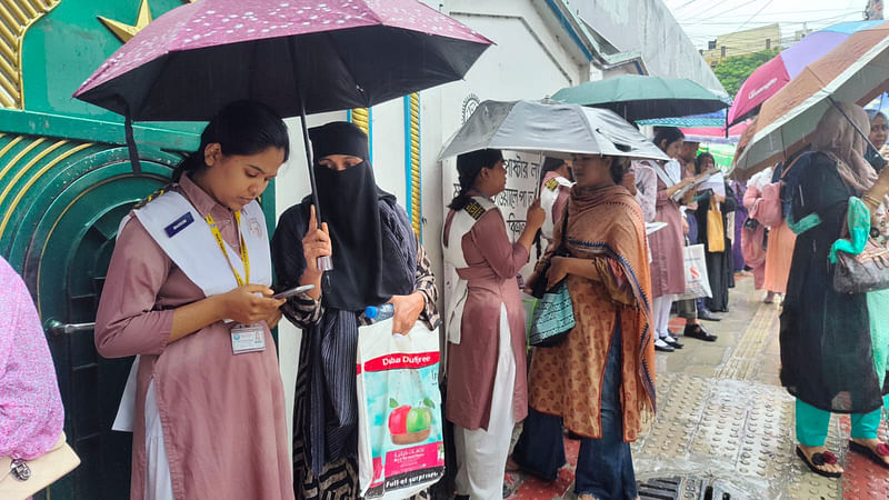 বৃষ্টিতে ছাতা মাথায় আরেক দফা পড়া চলছে। মোহাম্মদপুর কেন্দ্রীয় বিশ্ববিদ্যালয় কলেজের সামনে।