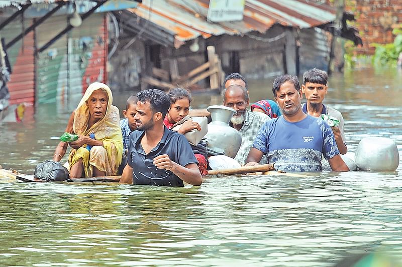 কলাগাছের ভেলায় করে নিরাপদ আশ্রয়ের উদ্দেশ্যে নিয়ে যাওয়া হচ্ছে বন্যাকবলিত কয়েকজনকে। ২৩ আগস্ট বেলা তিনটার দিকে ফেনী সদরের খাইয়ারা বাজার এলাকায়