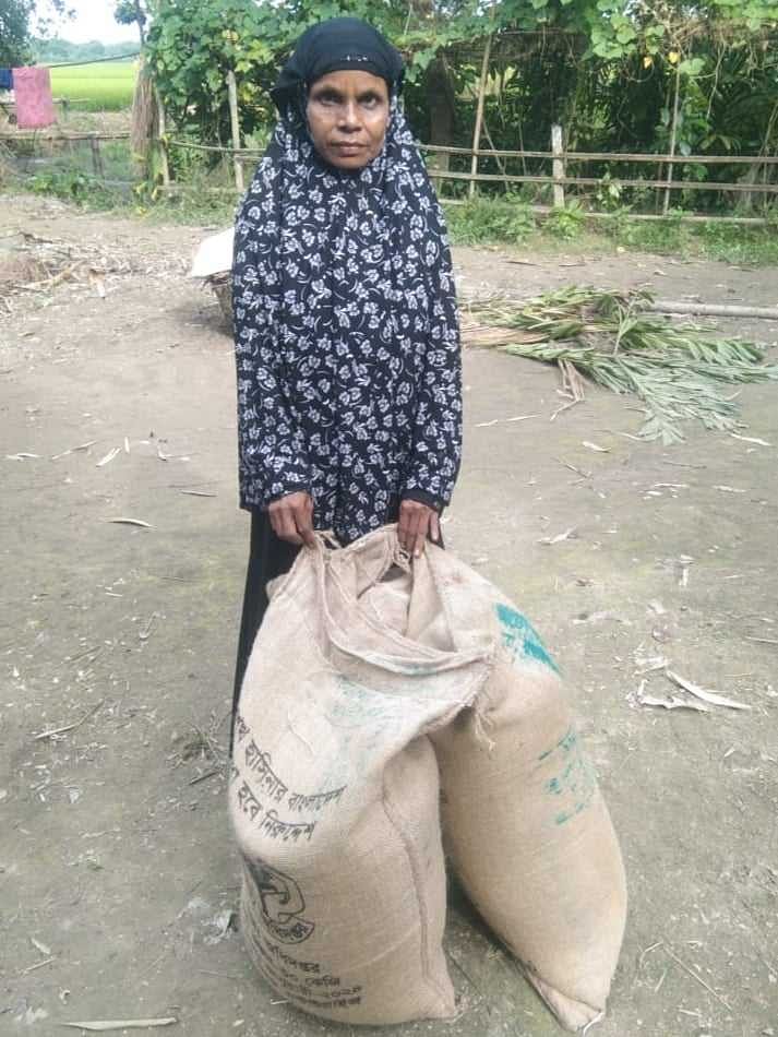 ভিডব্লিউবির ৯০ কেজি চাল নিয়ে বাড়িতে যাওয়ার জন্য সড়কের পাশে অপেক্ষা করছেন অনুপা। আজ বুধবার নান্দাইল উপজেলার চণ্ডীপাশা ইউপির অদূরেছবি: প্রথম আলো