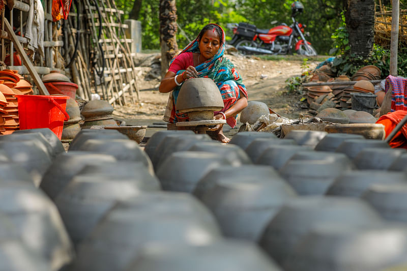 ফুলের টব তৈরিতে মনোযোগী একজন নারী। 