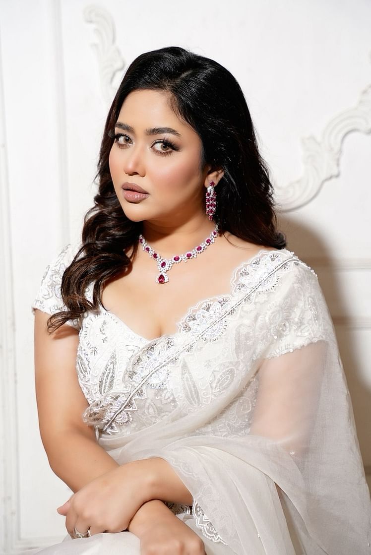সাদা শাড়ির সঙ্গে লাল-সাদা পাথরের ফ্যাশন জুয়েলারি পরেছেন ভাবনা কানে ও গলায়। হাতে আংটি রয়েছে শুধু।