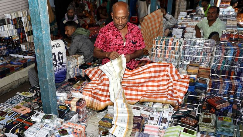 পাইকারিতে লুঙ্গির বিক্রির জন্য ক্রেতার অপেক্ষায় বিক্রেতারা