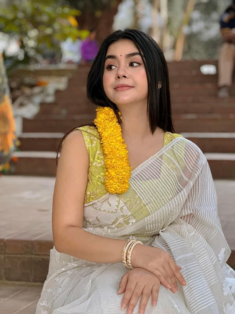 এখানে তিনি হলুদ স্লিভলেস ব্লাউজ দিয়ে সাদা জামদানি শাড়ি পরেছেন