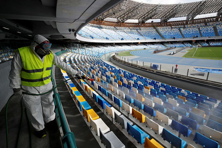 A cleaner wearing a protective suit sanitises seats at the San Paolo stadium. Photo: Reuters 