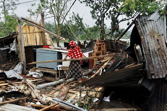 A woman clears her house that was demolished by the cyclone Amphan in Satkhira, Bangladesh 21 May, 2020. 