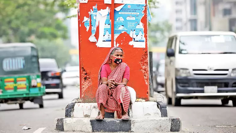 A woman waits for relief at Science Laboratory intersection in Dhaka on 7 May, 2020. 