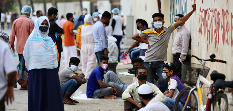 People waiting to be tested, lie on the ground early in the morning as they wait in the queue outside of a coronavirus testing centre amid concerns over coronavirus disease (COVID-19) outbreak in Dhaka, Bangladesh, 17 May 17, 2020. 