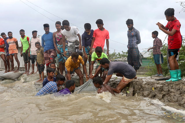 Local people try to enforce the embankment before the cyclone Amphan makes its landfall in Gabura outskirts of Satkhira district on 20 May 2020. 