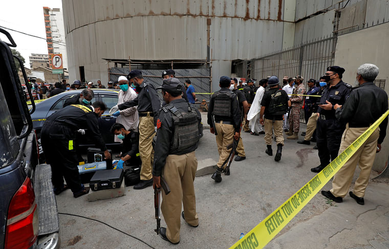 Members of the Crime Scene Unit of Karachi Police prepare to survey the site of an attack at the Pakistan Stock Exchange entrance in Karachi 29 June.